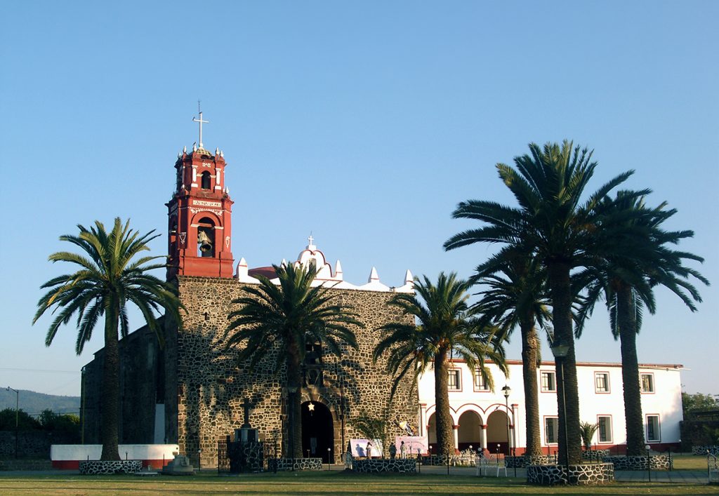 Vista frontal de la fachada arquitectónica de la histórica Iglesia San Miguel de Atlautla durante los trabajos de mantenimiento.