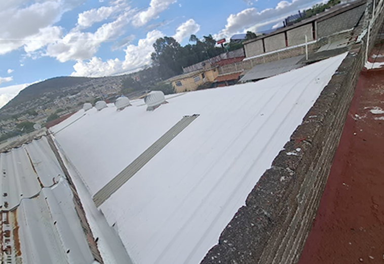 Techo de lámina metálica en almacén de muebles totalmente rehabilitado e impermeabilizado con recubrimiento reflectante blanco.